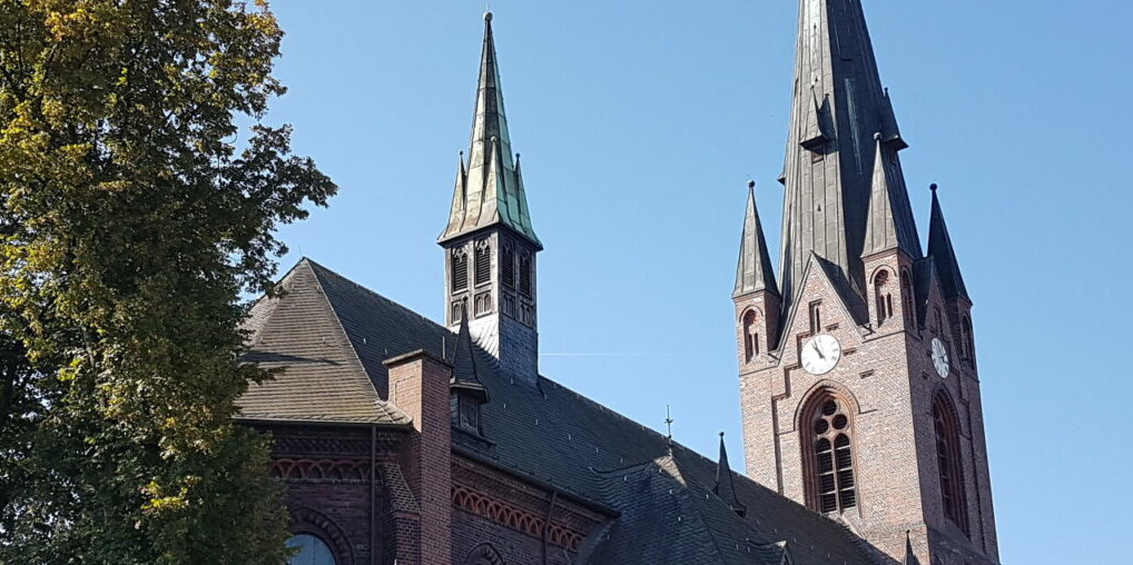 Dach und Kirchturmspitze vor blauem Himmel